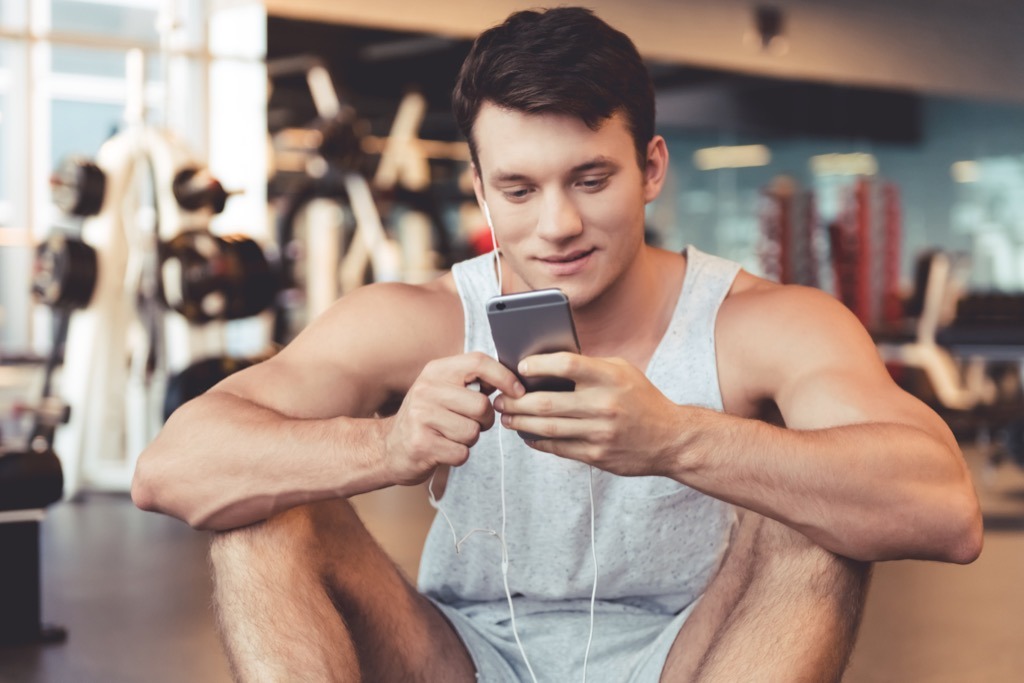man listening to music at the gym, weight loss motivation