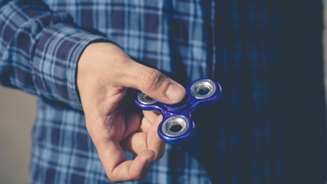 man holding a fidget spinner