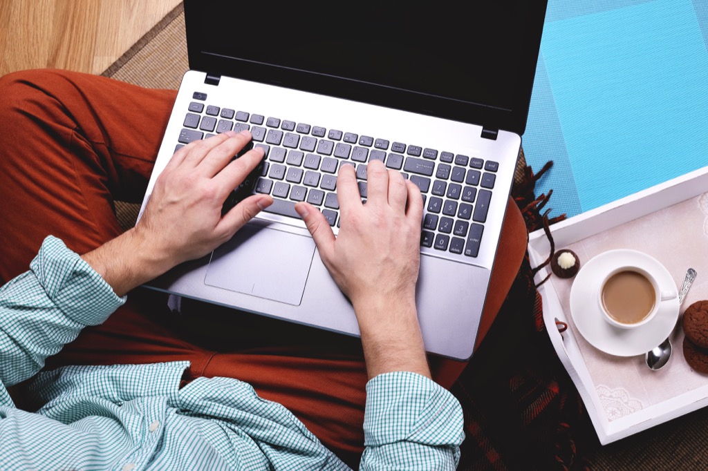 Overheard close up view of man working on laptop