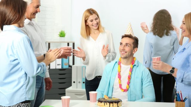 A man celebrating a birthday at work.