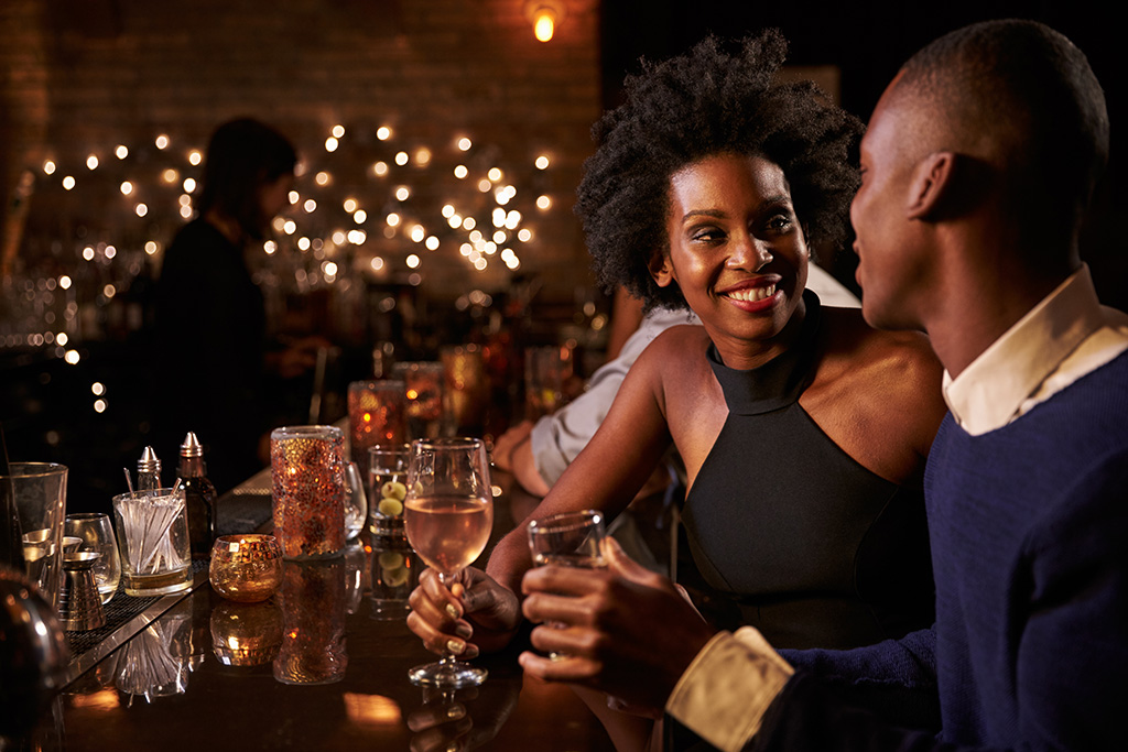 woman and man on a date at a wine bar, how to tell if a girl likes you