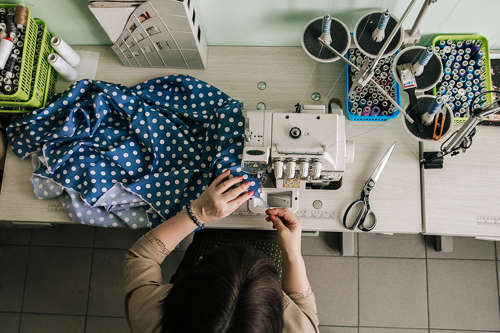 seamstress fixing hem, sewing machine, thrift store