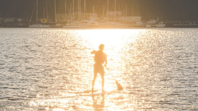 Man paddleboarding in Seattle, one of the healthiest cities in America.