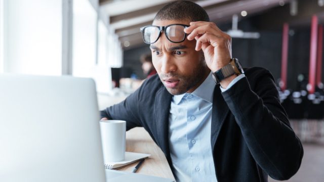 man looking at computer shocked