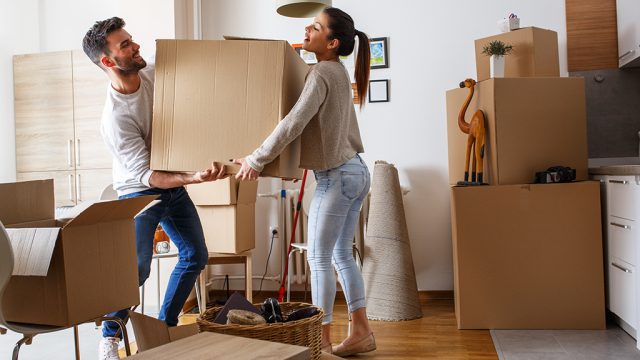 young couple moving boxes into new house, living together before marriage