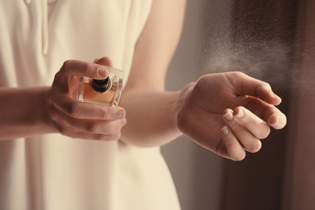 woman spraying perfume floral