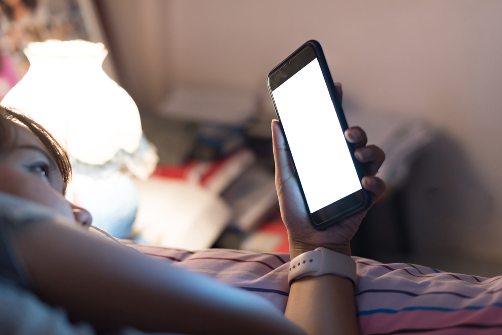 woman phone in bed healthy skin after 40