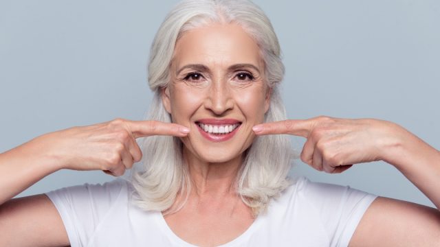 older white woman smiling showing off perfect teeth