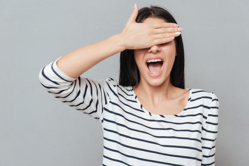 Woman covering eyes while telling riddle