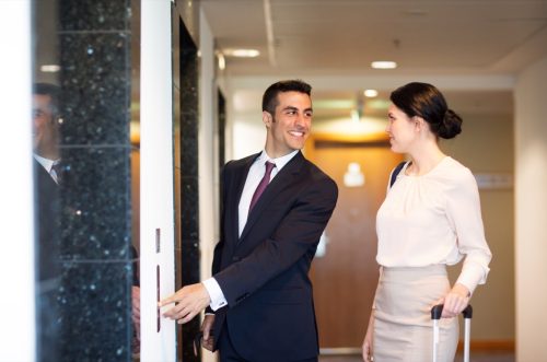 man letting woman off elevator