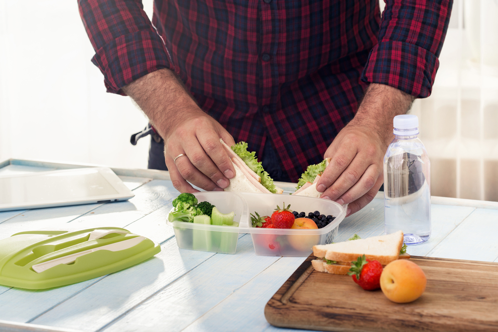 Man making school healthy lunch in the morning in the home kitchen