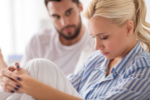 woman looking sad as a man talks to her