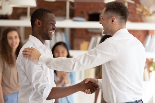Boss thanking congratulating employee shaking hands