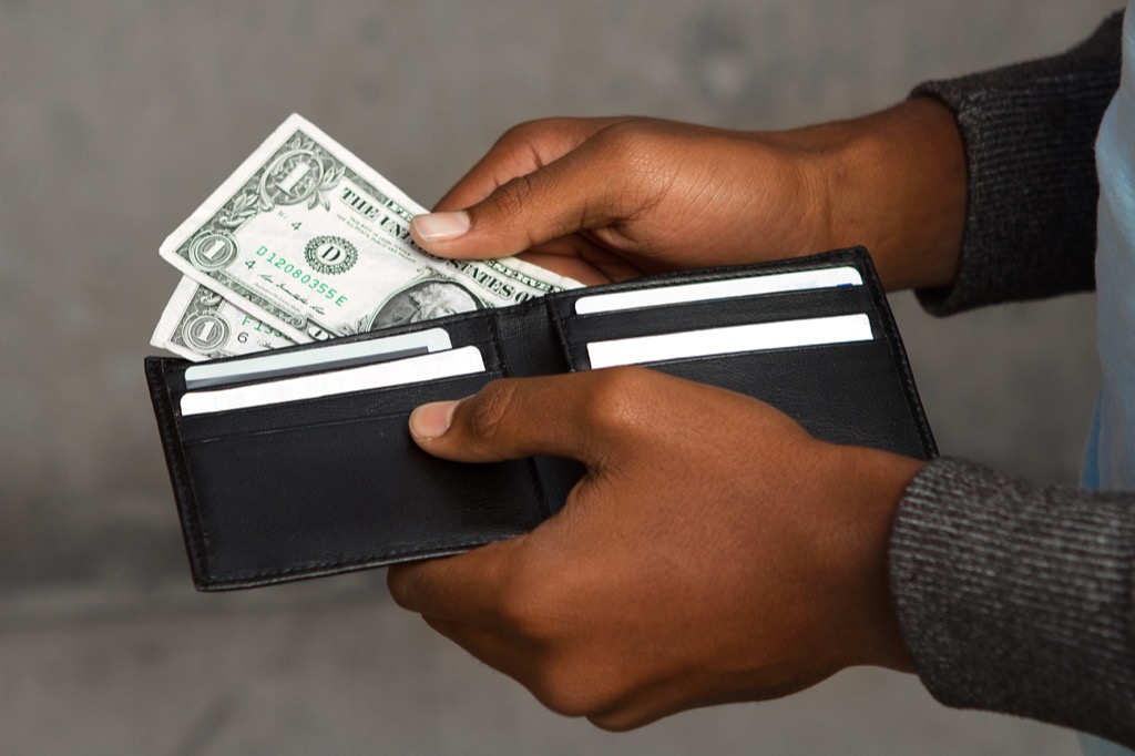 man taking money out of a wallet, things you should never say to your spouse