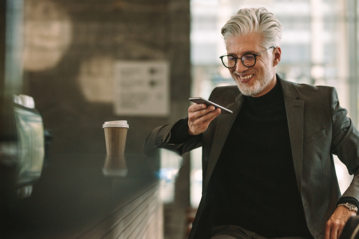 older man talking on speakerphone at a cafe, etiquette mistakes