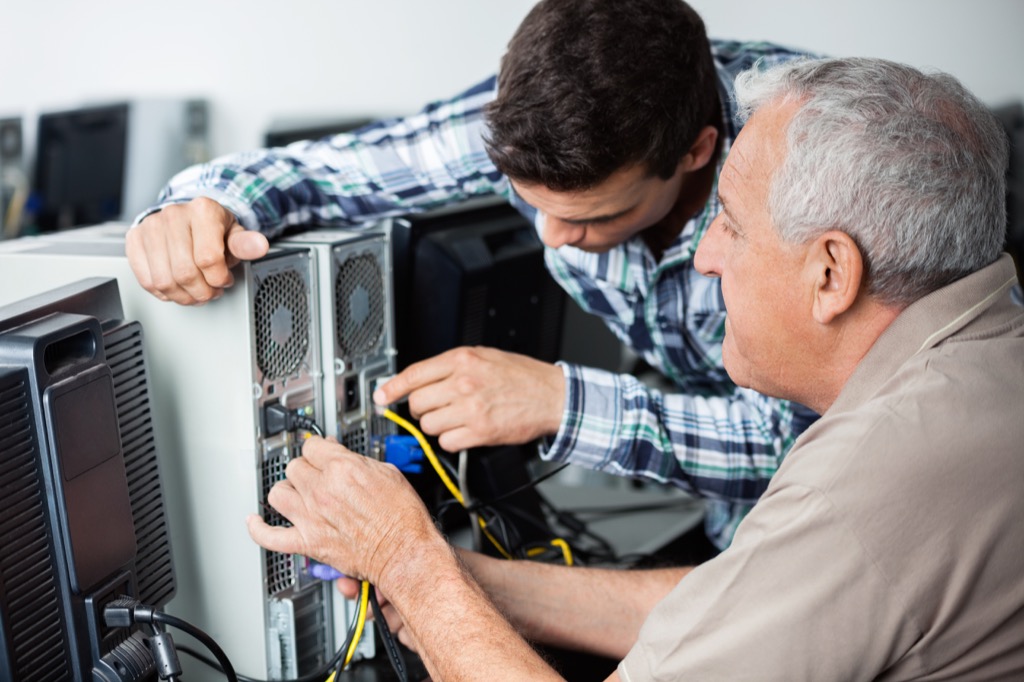 Millennial man helping Baby boomer 