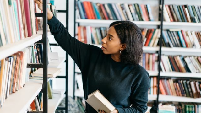 Young black woman selecting a book