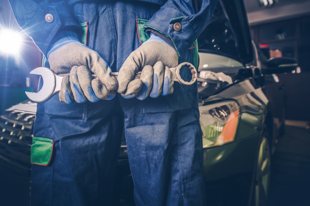 car mechanic holding wrench