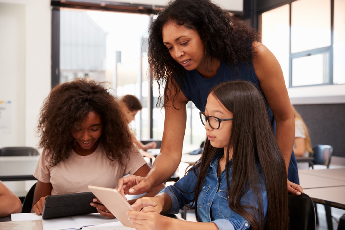 female teacher helping students in classroom lies teachers tell parents