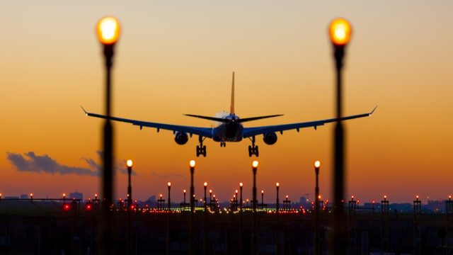 airplane landing at sunset