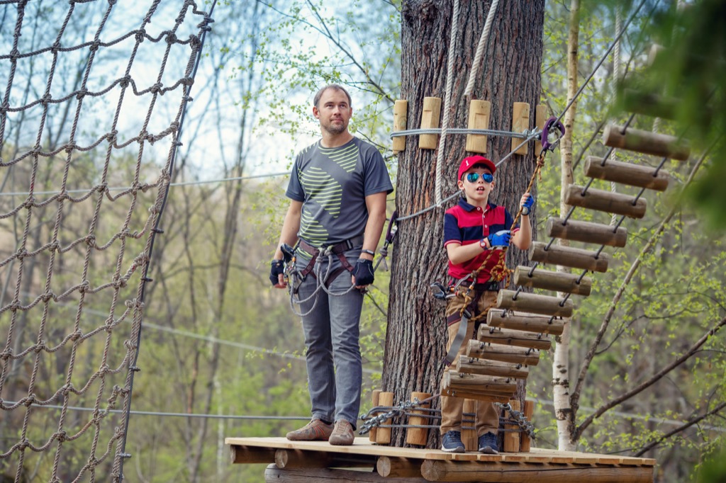 dad waiting to climb rope bridge with son