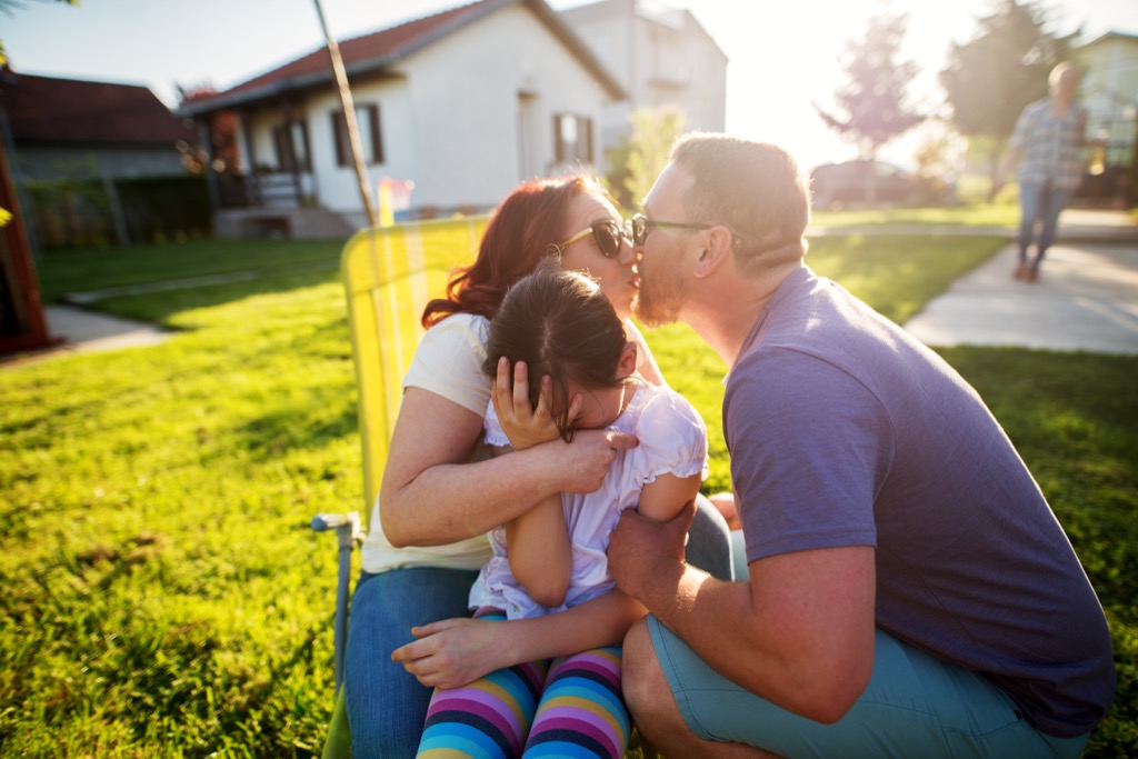 little girl embarrassed by parents kissing