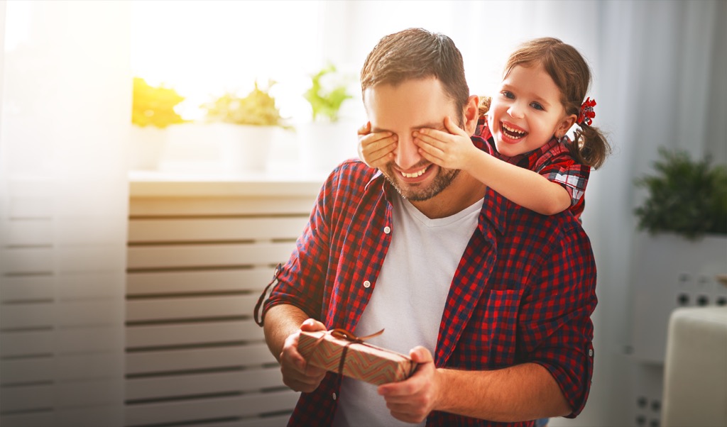 little girl surprising dad with present 