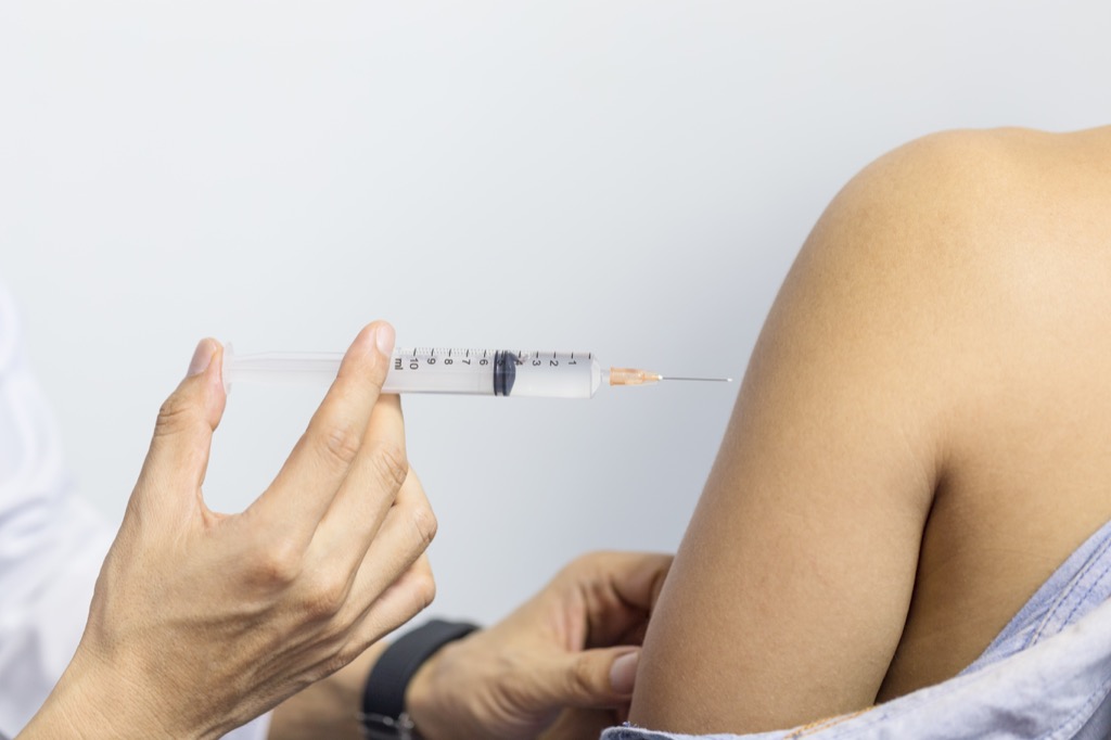 Doctor with a needle giving a shot, injectable medications