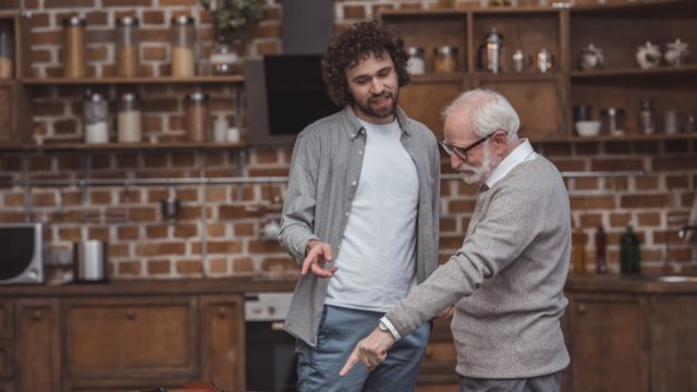 father and son pointing at table soccer game