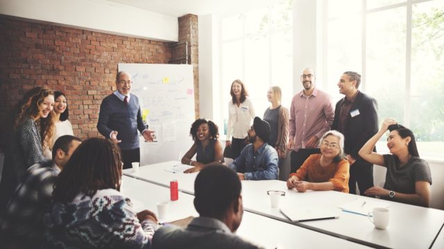 smiling boss in a brick-walled conference room icebreaker games