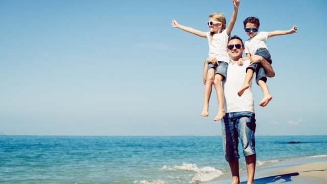 father with son and daughter on a beach