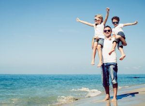 father with son and daughter on a beach