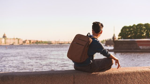 man sitting alone by a european river