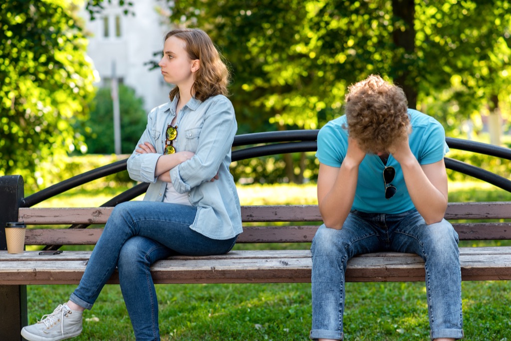 couple arguing on park bench, things you should never say to your spouse