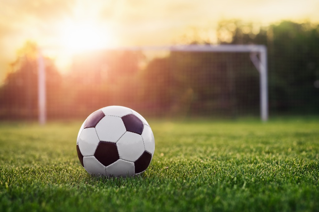 Soccer ball on field at sunset
