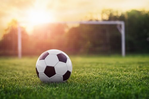 soccer ball on field during sunset