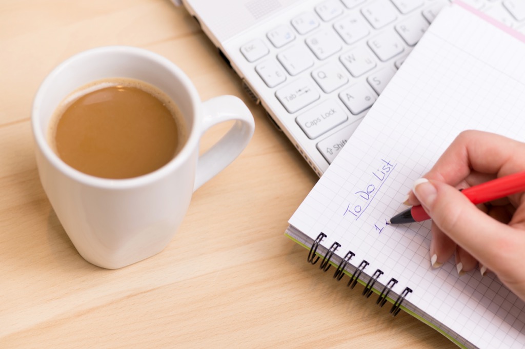 Woman being productive and writing a to-do list, ways to feel amazing