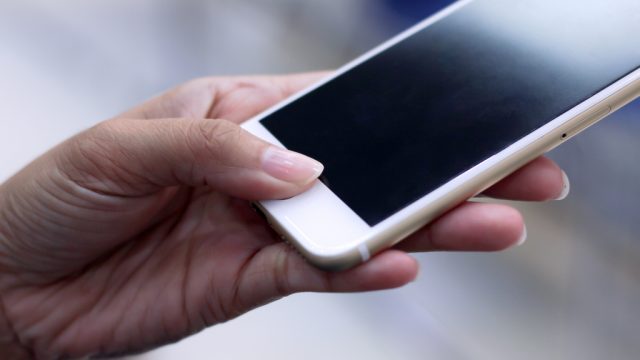 Woman Using Fingerprint Scanner on Smartphone things you should clean every day