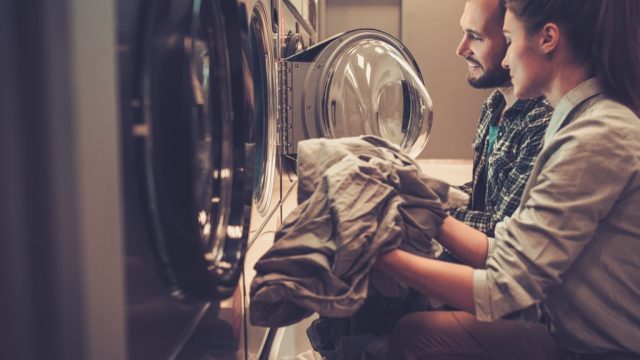 young couple doing laundry in a laundromat