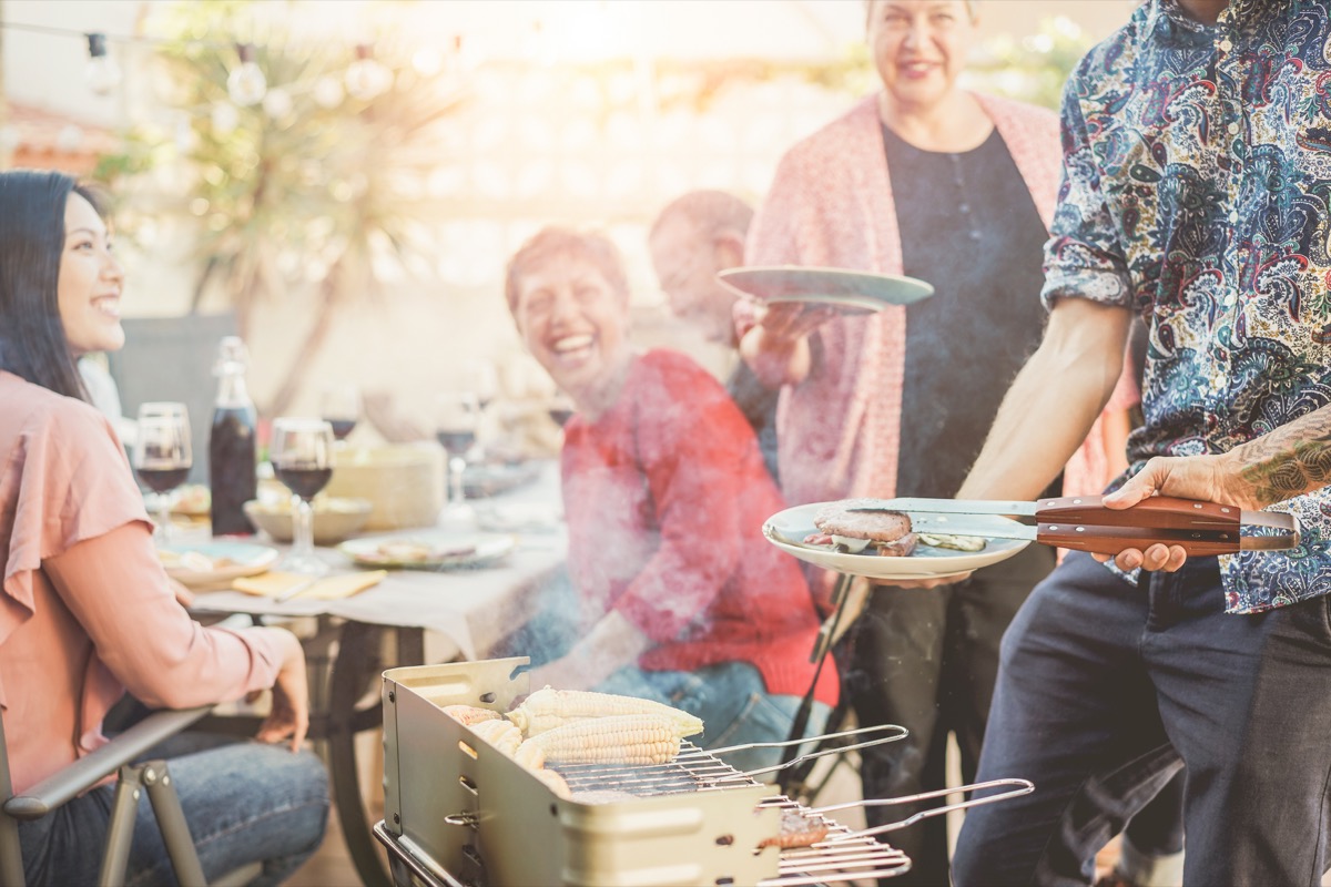 man making a plate at a backyard barbecue party