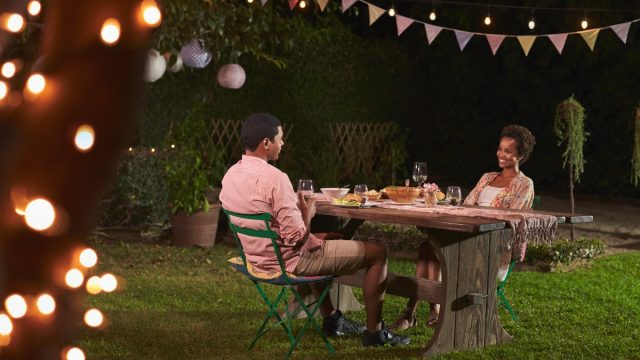 young black couple having dinner outside in garden