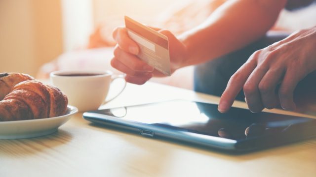 hands holding a credit card shopping online with a tablet