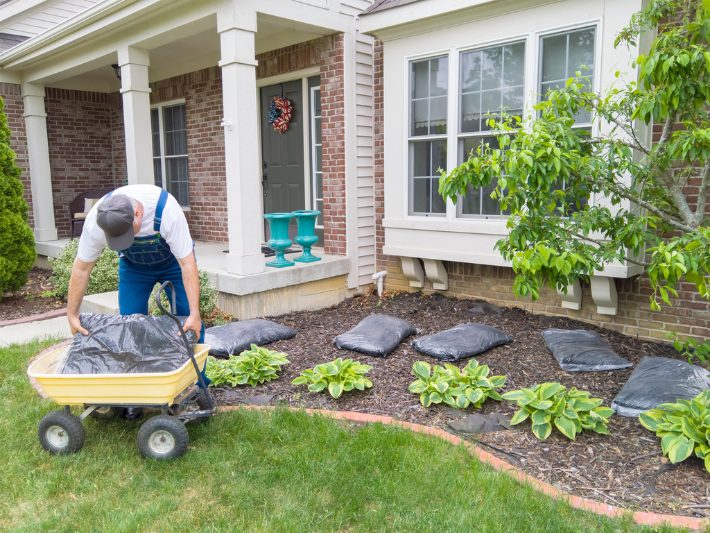 Man Putting Mulch in Yard Boosting Your Home's Curb Appeal