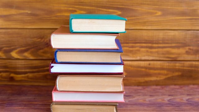 stack of hardcover books, get rid of stuff to be happier