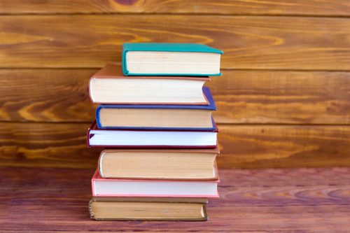 stack of hardcover books, get rid of stuff to be happier