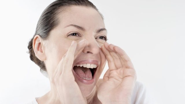 Mature woman shouting and screaming isolated over white background