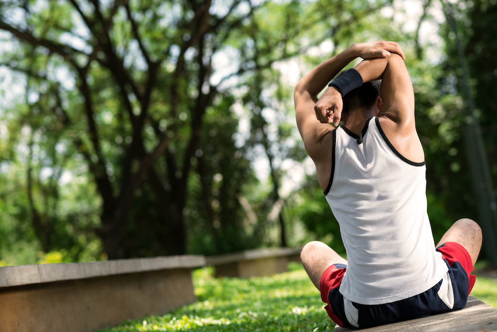 man stretching with a sweatband on his wrist ways to de-stress