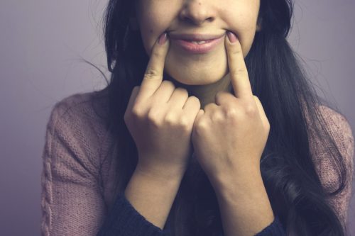Sad Woman Pretending to Smile {Body Language Cues}
