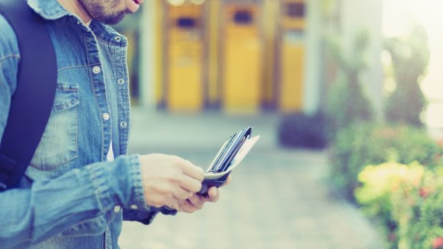 man with a beard pulling cash out of his wallet, worst things about the suburbs
