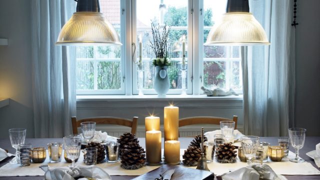 Dinner table ready for christmas dinner with pinecones and candles